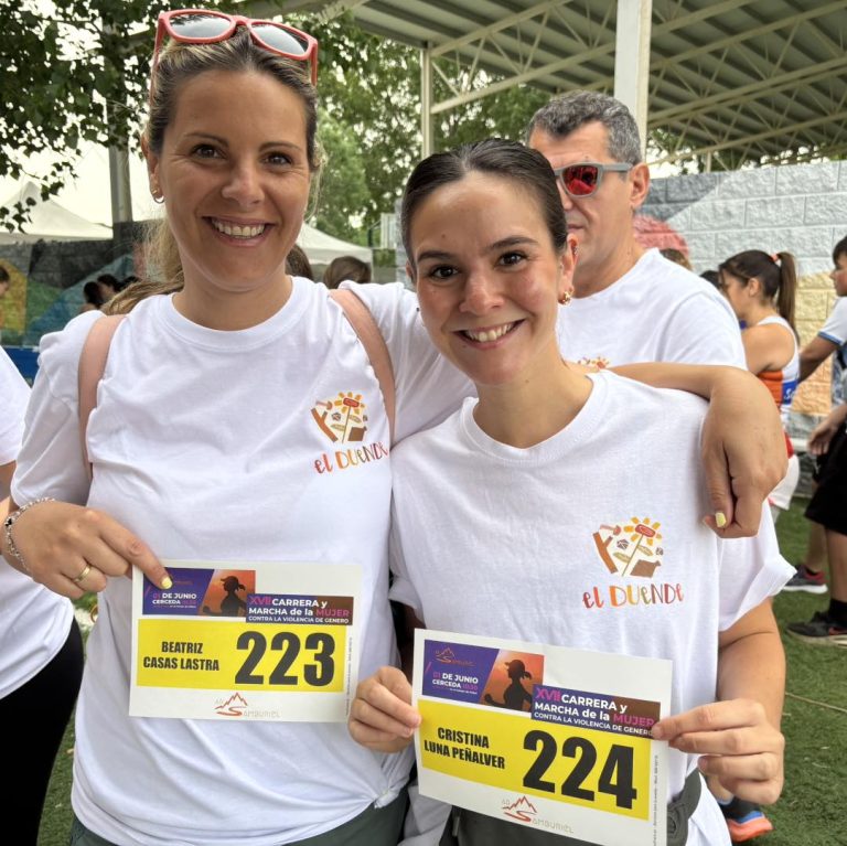 Dos mujeres sonríen mostrando sus dorsales para la "Carrera y Marcha de la Mujer contra la violencia de género